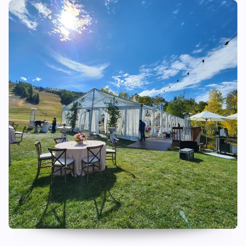 outdoor table with clear tent and wooden tables and chairs