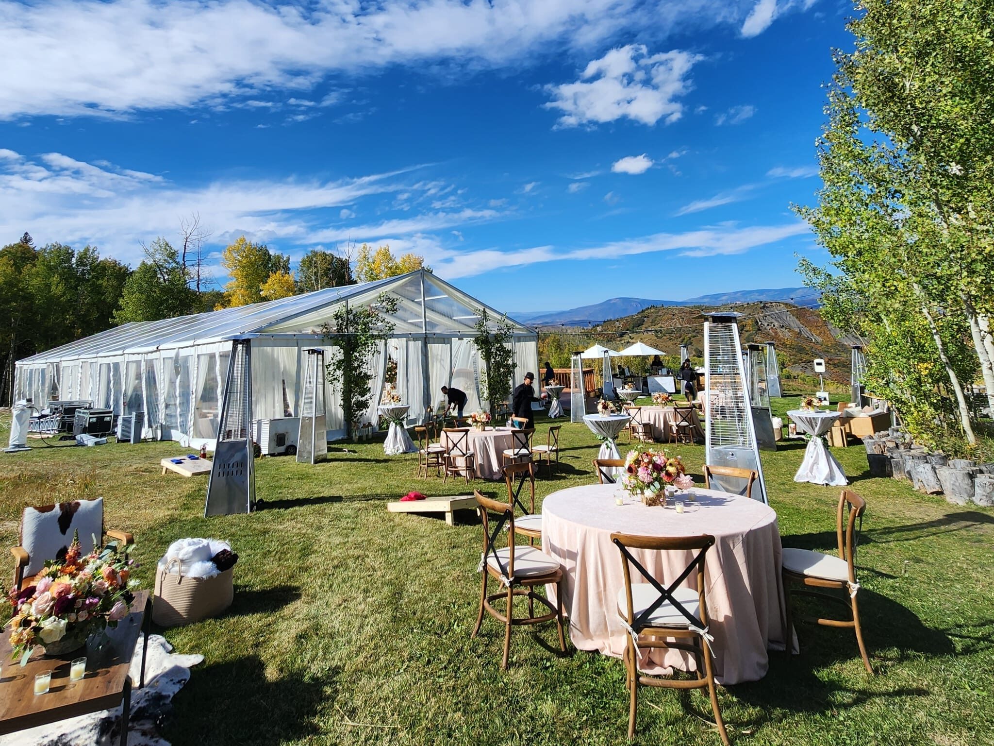 outdoor wedding with tent and wooden table rentals